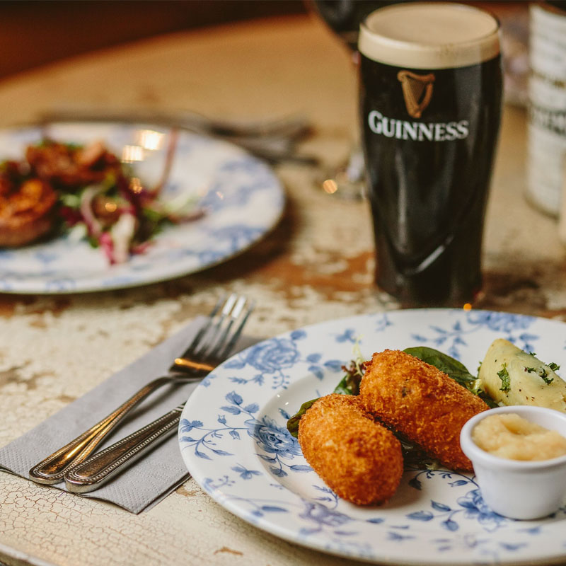 Close up shot of Guinness and croquettes on the table